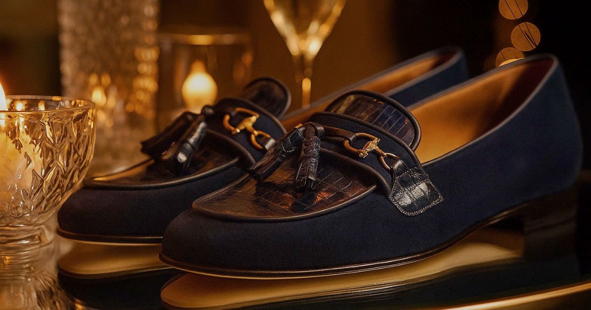 Elegant navy suede loafers with crocodile-pattern leather details and gold metal horsebite accents