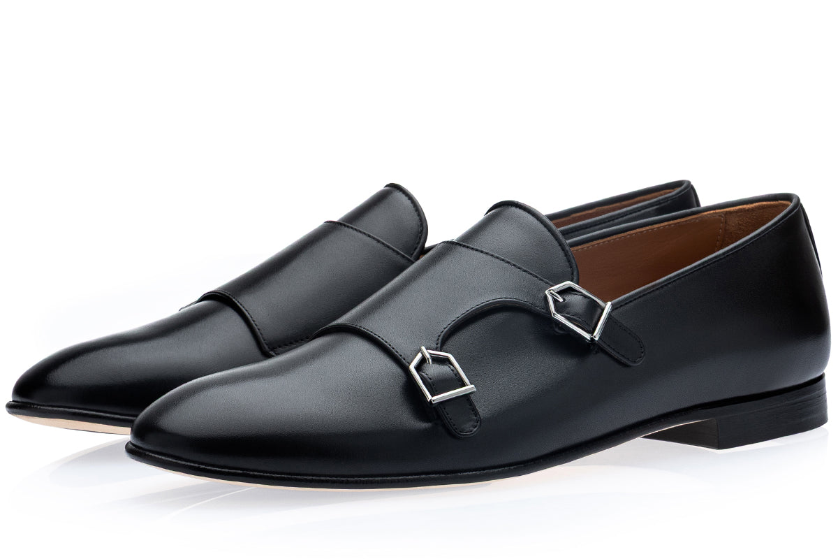 A pair of men's black leather double monk loafers with silver buckle details, displayed on a clean white background.