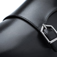 Close-up of a black leather strap with a silver-toned metal buckle on a white background. | Image 5
