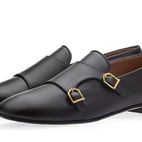 A pair of men's cocoa leather slip-on loafers with double buckle straps and gold-tone hardware, displayed on a clean white background. | Image 1