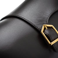 Close-up of a cocoa leather strap with a gold buckle on a black leather item, photographed against a white background. | Image 5