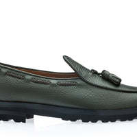 A musk green pebbled leather loafer with a tassel detail on the vamp and a chunky black lug sole, shown from a side profile on a white background. | Image 3