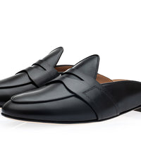 A pair of black leather penny loafer mule slides with a low block heel, displayed on a clean white background. | Image 1